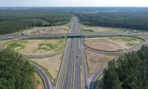 Rozległy węzeł drogowy autostrady A6 otoczony lasami. Widać wielopoziomowe skrzyżowania, drogi dojazdowe i pasy ruchu.