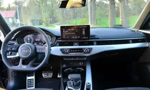 Wnętrze Audi b9 z ekranem multimediów, cyfrowymi zegarami i automatyczną skrzynią biegów.