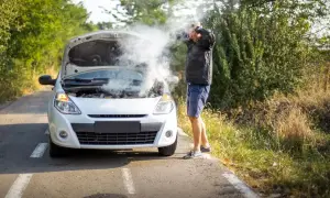 Rozbiegany diesel dymi spod maski, a kierowca w rozpaczy łapie się za głowę. Awaria na drodze w upalny dzień.