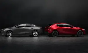 Szary sedan Mazda 3 i czerwony hatchback stoją obok siebie na ciemnym tle.