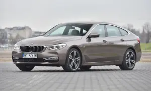 Eleganckie bmw g32 w kolorze brązowym, zaparkowane na płycie chodnikowej.