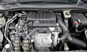 Silnik Citroen C4 1.6 HDI, widok z góry. Widać turbosprężarkę, przewody i osłonę silnika z logo producenta.