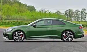 Zielone coupe z czerwonymi zaciskami hamulcowymi jedzie po torze.