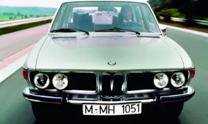 Klasyczny srebrny BMW E3 jedzie autostradą.