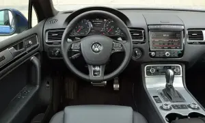 Wnętrze Touarega 3.0 TDI: kierownica, deska rozdzielcza z radiem i panelem klimatyzacji, dźwignia zmiany biegów.