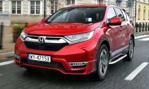 Czerwony Honda CRV 2024 jedzie ulicą.