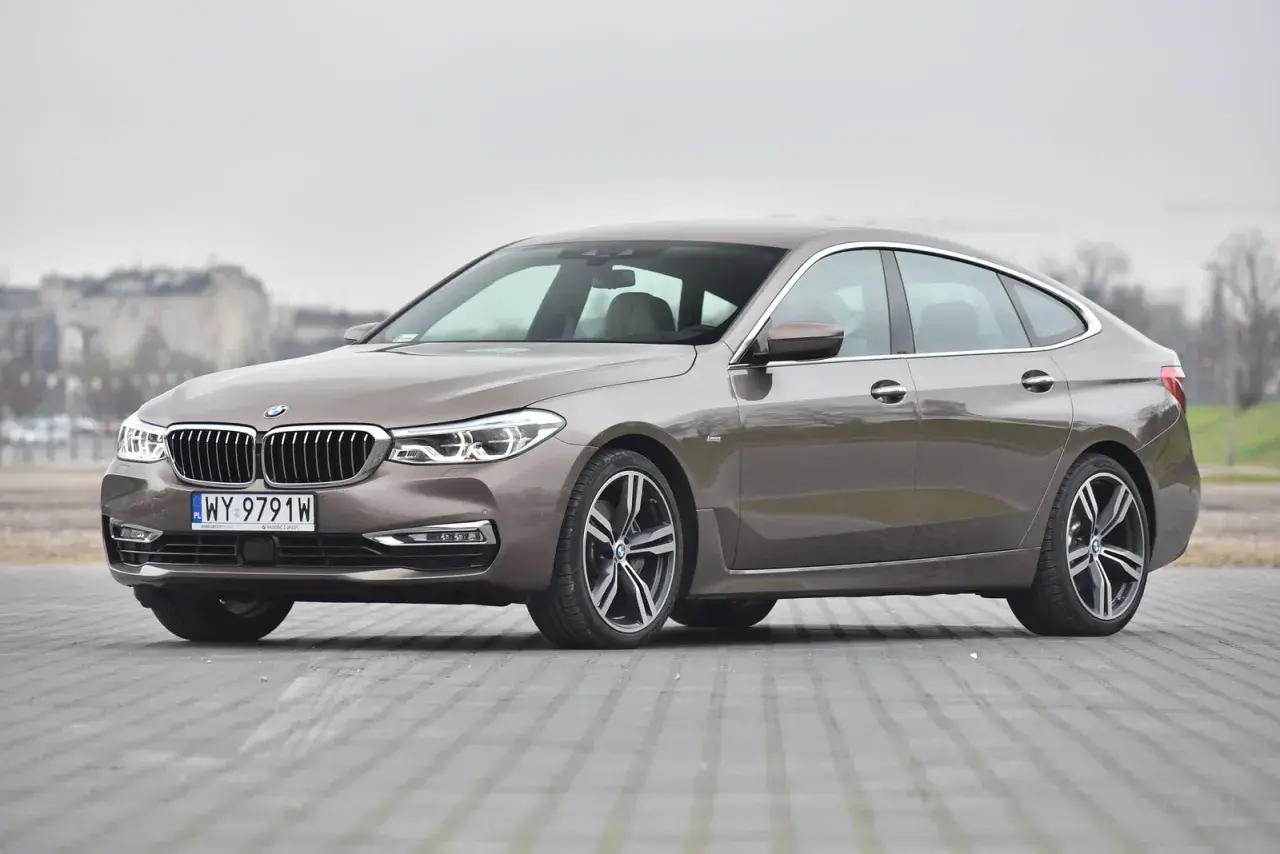 Eleganckie bmw g32 w kolorze brązowym, zaparkowane na płycie chodnikowej.