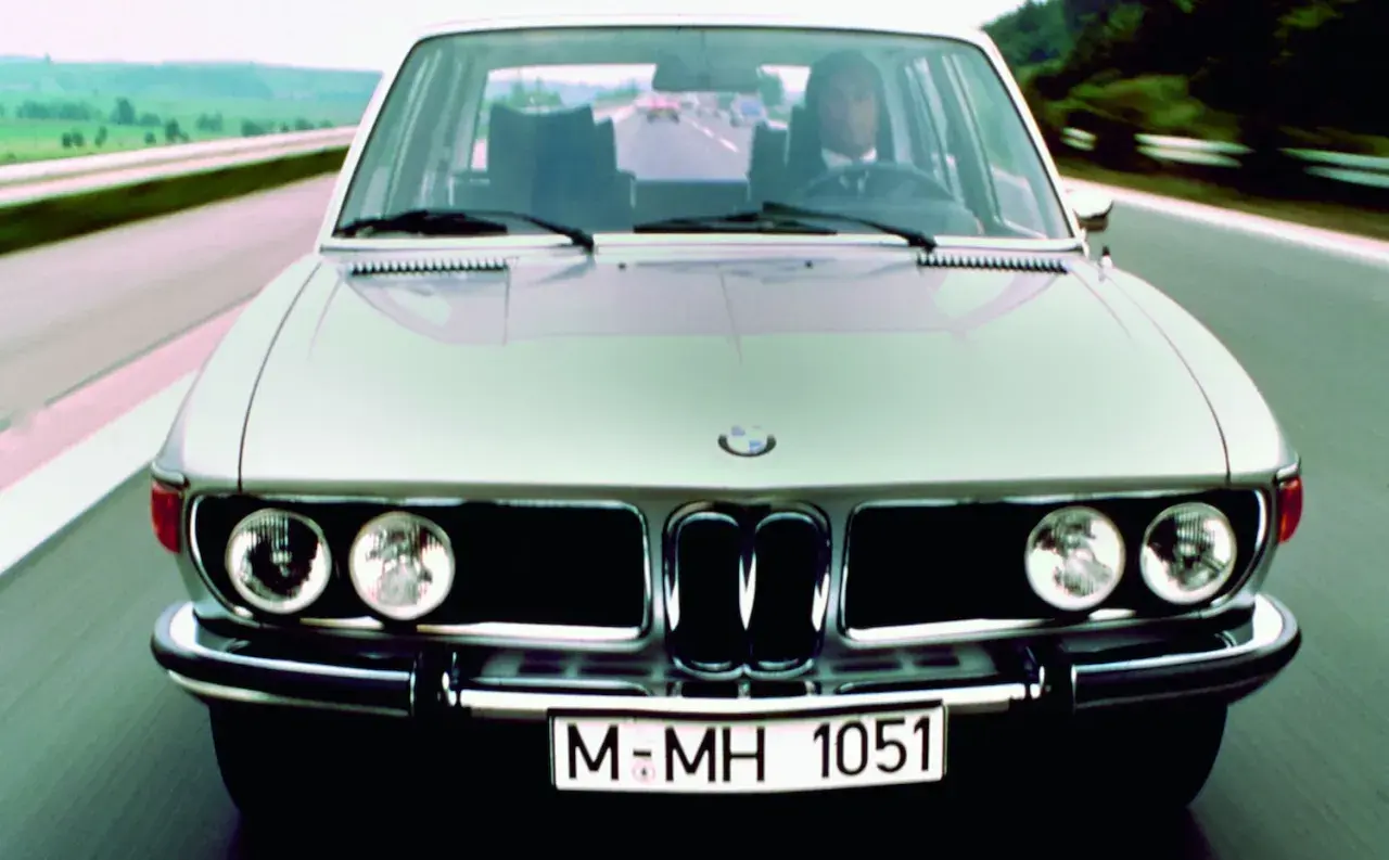 Klasyczny srebrny BMW E3 jedzie autostradą.