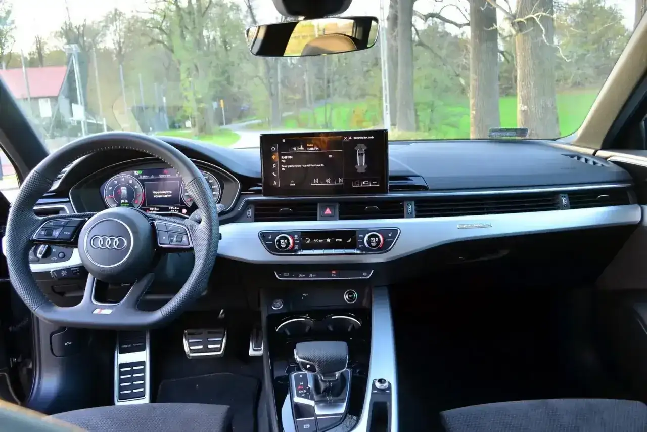 Wnętrze Audi b9 z ekranem multimediów, cyfrowymi zegarami i automatyczną skrzynią biegów.