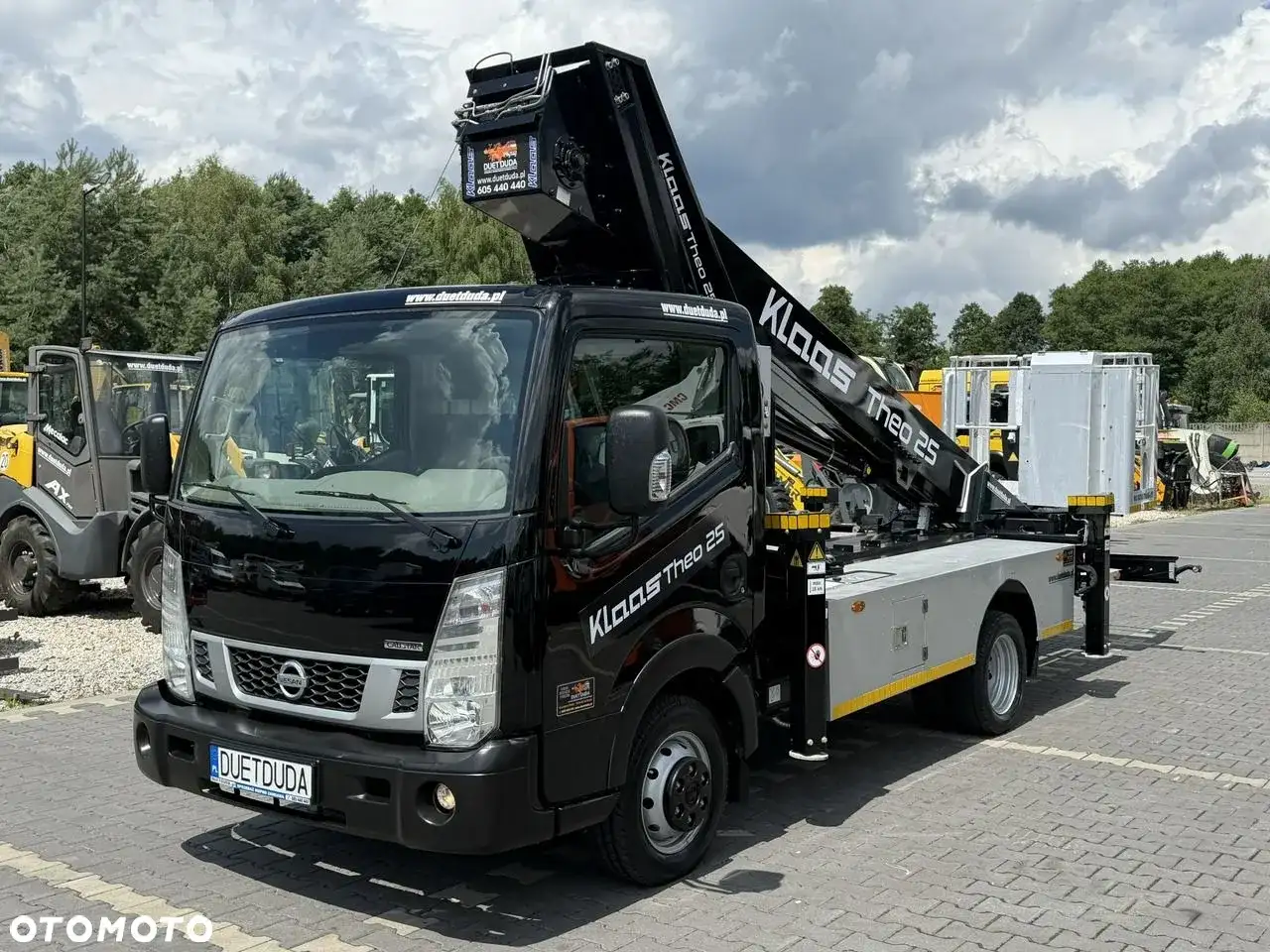 Czarny Nissan Cabstar z podnośnikiem Klaas Theo 25 gotowy do pracy.