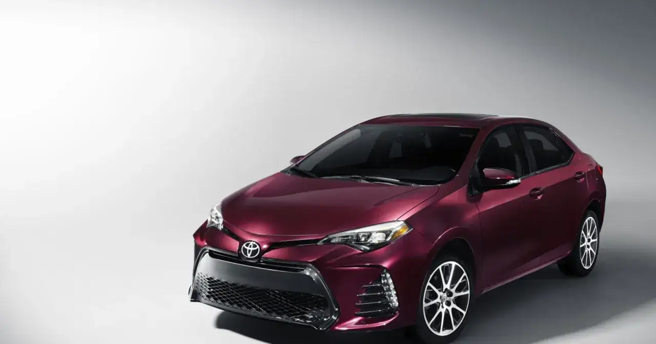 Elegancka, bordowa Toyota Corolla 2017 z przyciemnianymi szybami i chromowanymi felgami, prezentowana na jasnym tle.