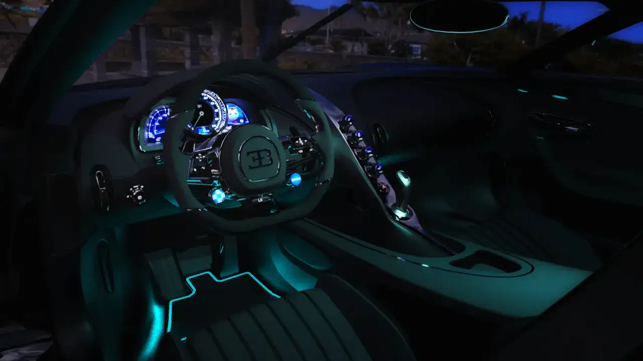 Wnętrze Bugatti La Voiture Noire, z niebieskim podświetleniem, kierownicą i deską rozdzielczą.