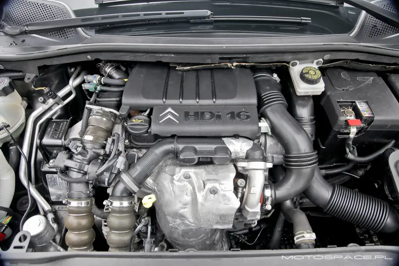 Silnik Citroen C4 1.6 HDi, widok z góry. Widać turbosprężarkę, przewody i osłonę silnika z logo Citroen.