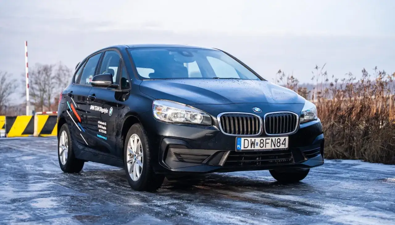 Czarny BMW serii 2 Active Tourer F45 na oblodzonej drodze.
