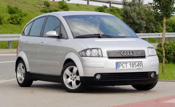Srebrny Audi A2, kompaktowy samochód z charakterystycznymi, zaokrąglonymi liniami, prezentuje swoje a2 wymiary na tle zieleni.