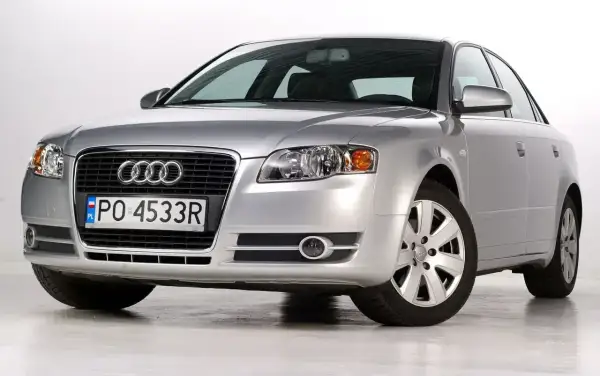 Srebrny Audi B7 z polskimi tablicami PO 4533R, prezentujący się elegancko na białym tle.