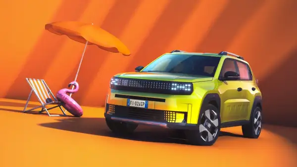 Nowy Fiat Panda w jaskrawym kolorze, gotowy na wakacje. Obok leżak, parasol i dmuchany flaming.