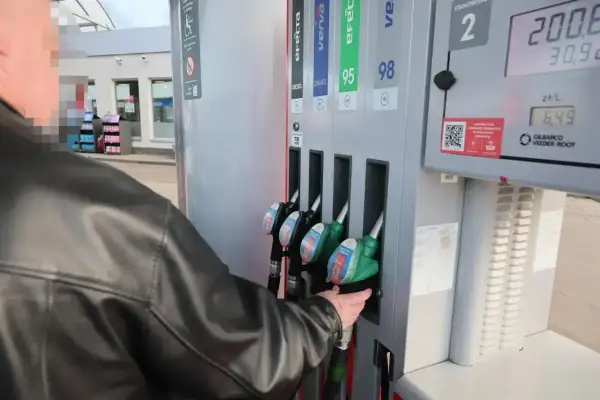 Mężczyzna w czarnej kurtce sięga po dystrybutor z napisem "verva diesel" na stacji paliw.