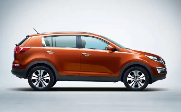 Pomarańczowy Kia Sportage 2015 z profilu, gotowy na przygodę.