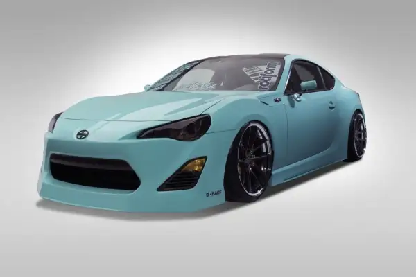 Turkusowy Scion FR-S z przyciemnionymi światłami i czarnymi felgami, gotowy do jazdy.