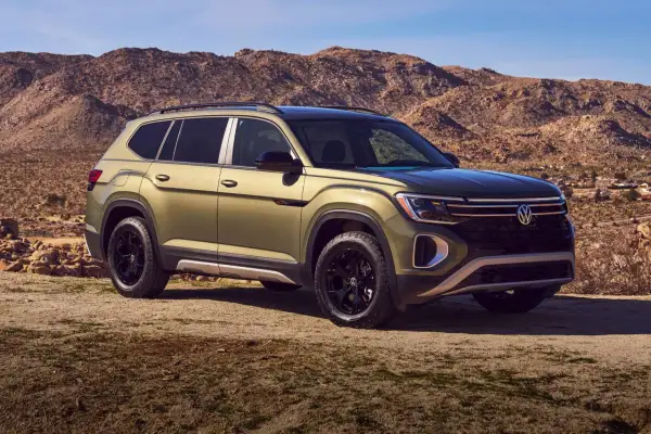 Zielony VW Atlas z czarnymi felgami na tle pustynnego krajobrazu.