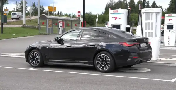 Czarne BMW i4 na ładowarce Ionity. Elektryczny samochód gotowy do podróży.