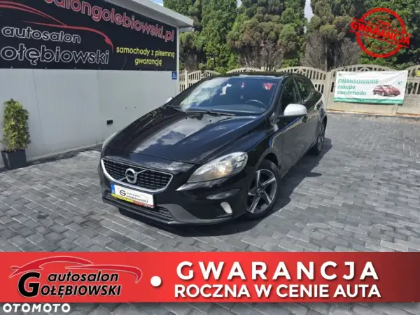 Czarny Volvo V40 z 2015 roku na placu autokomisu Gołębiowski. Oferta obejmuje roczną gwarancję w cenie auta.
