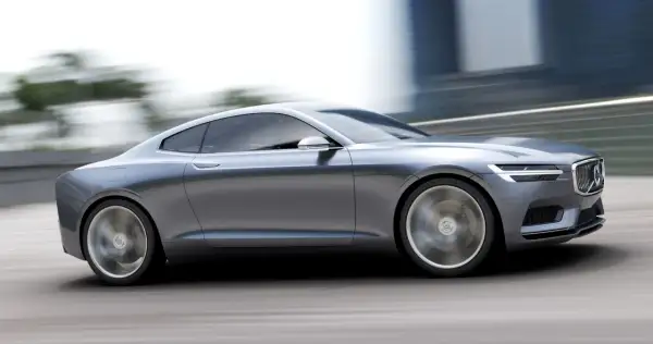 Eleganckie, szare volvo coupe pędzi po drodze, rozmywając tło.