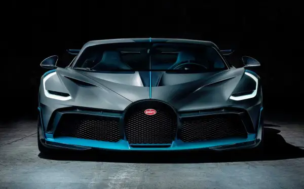 Szary Bugatti Divo z niebieskimi akcentami, przód samochodu na ciemnym tle.